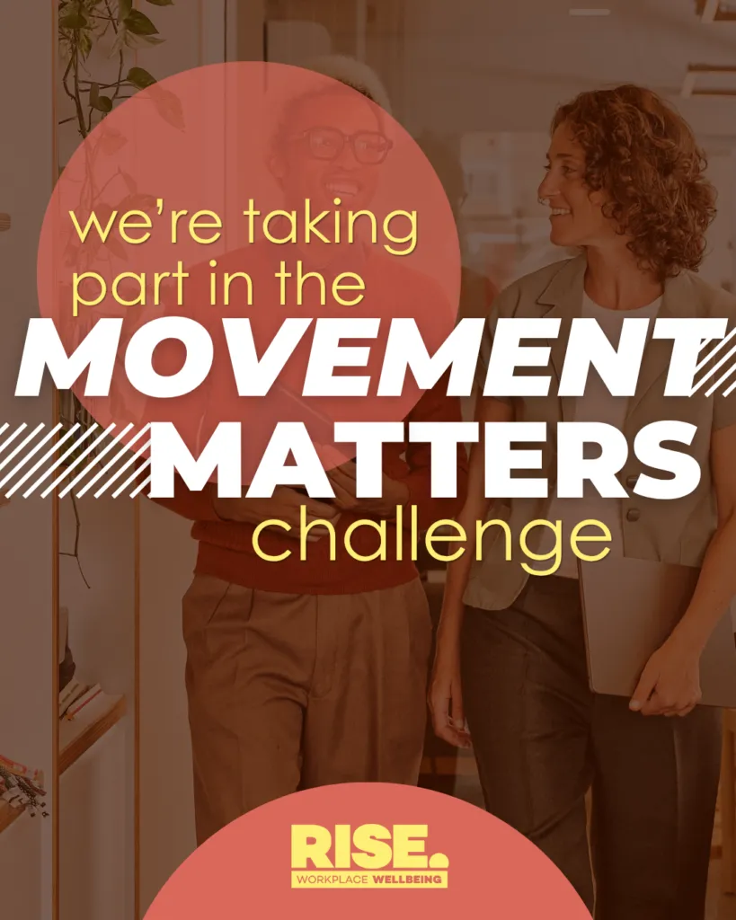 Two colleagues smile while walking through an office carrying laptops and folders. Overlaid text reads: "We're taking part in the Movement Matters Challenge." Rise Workplace Wellbeing logo at the bottom.