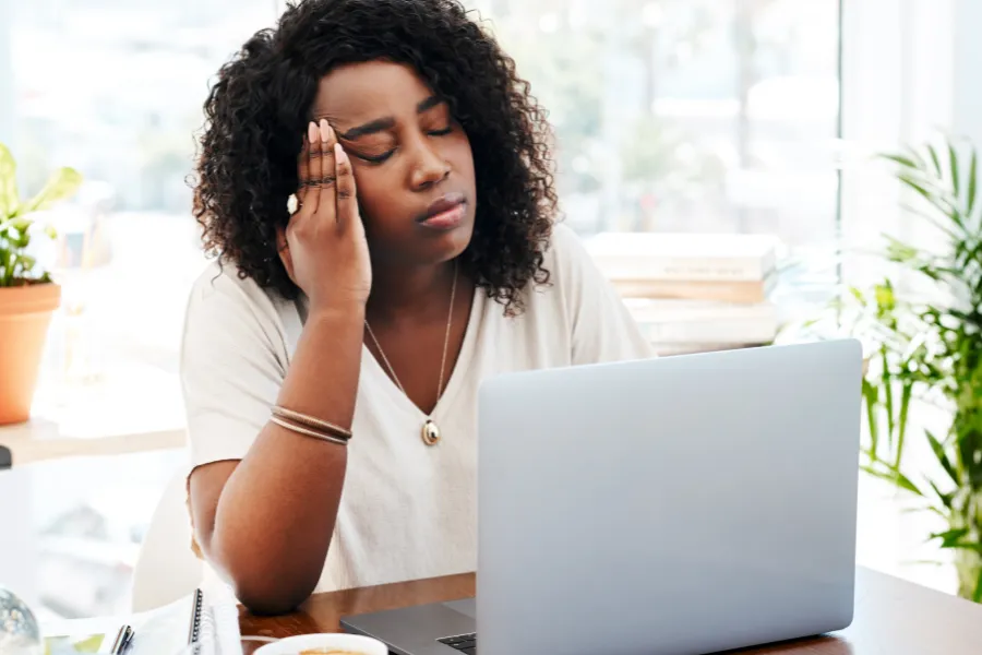 woman at her work desk looking stressed and burnout